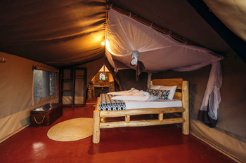 Tindiga Tented Camp: Rustikales Holzbett mit Moskitonetz im Zelt