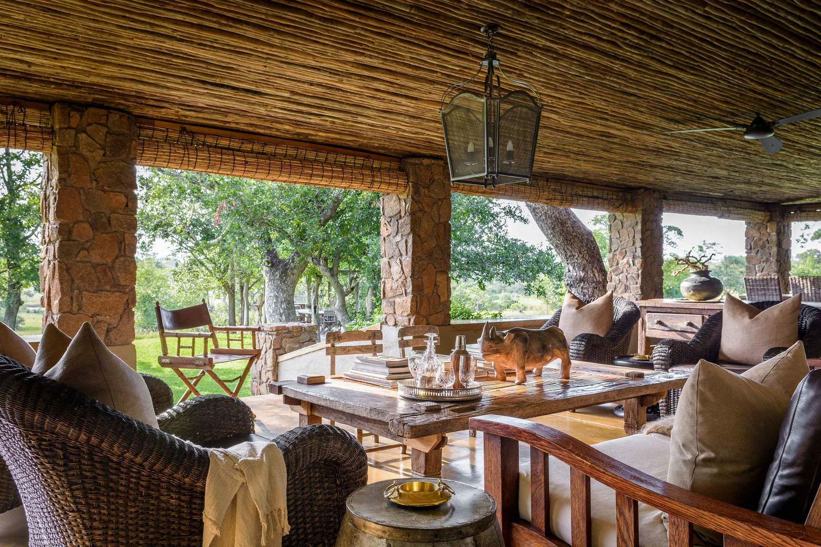 Singita Castleton Singita Castleton: Veranda-Lounge mit Rattansesseln und Cocktailtablett