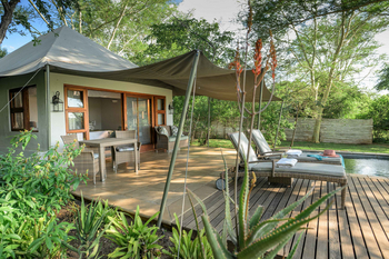 Savanna Lodge: Pooldeck mit Rattanliegen und weißen Handtüchern