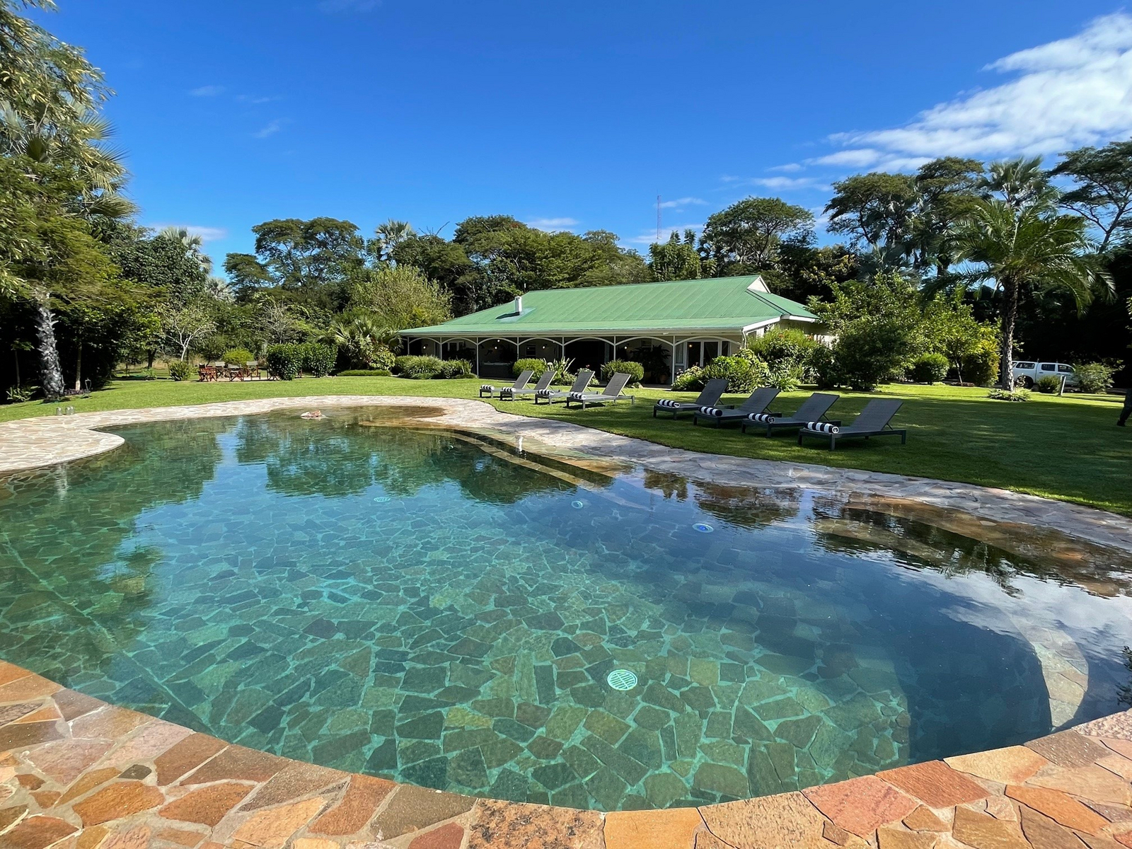 The River Farmhouse The River Farmhouse: Großer Pool mit Steinfliesen vom Karibasee