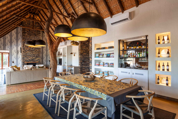 Little Madikwe Hills: Speisesaal mit Holzstühlen und Kamin