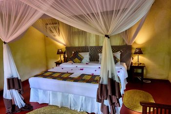 Moivaro Lodge: Schlafzimmer mit Baldachin und Blumenakzenten