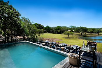 andBeyond Phinda Zuka Lodge: Sonniges Pooldeck mit Liegen und Busch