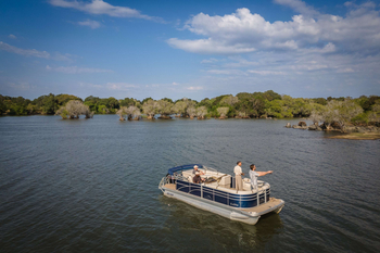 Anantara Tented Camp Kafue River: Gäste angeln vom Pontonboot auf ruhigem Fluss