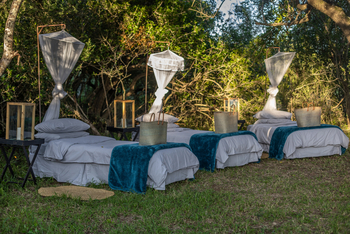 andBeyond Phinda Zuka Lodge: Drei Open-Air-Betten unter goldenem Licht