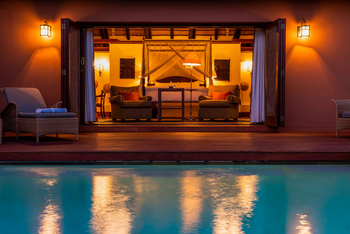 Mateya Safari Lodge: Abendliches Poolambiente mit Blick ins Schlafzimmer
