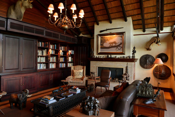 Mateya Safari Lodge: Elegantes Wohnzimmer mit Kamin und Bücherwand
