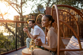 Anantara Tented Camp Kafue River: Zwei Gäste beim goldenen Sundowner auf Deck