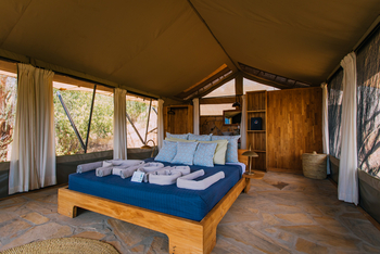 Mkomazi Wilderness Retreat: Helles Schlafzelt mit Holzbett und Steinwaschtisch