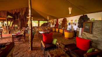 Ikoma Tented Camp: Lounge Stühle mit roten Kissen bei Tag