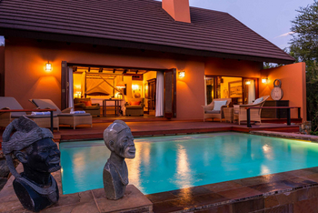 Mateya Safari Lodge: Poolbereich mit Sonnenliegen am Abend