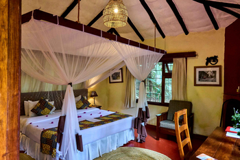 Moivaro Lodge: Großes Bett mit bunten Mustern und Moskitonetz