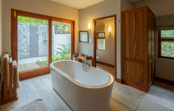 Savanna Lodge: Badezimmer mit freistehender Wanne und Holzboden