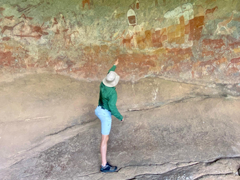 Big Cave Camp Big Cave Camp: Mensch zeigt auf Wandmalerei