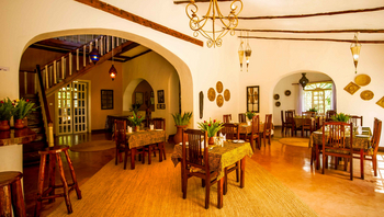Arusha Safari Lodge: Elegantes Esszimmer mit Holzmöbeln und Pflanzen