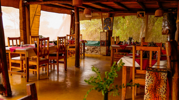 Ikoma Tented Camp: Rustikale Speisebereich mit Holzmöbeln und Kulturdekor
