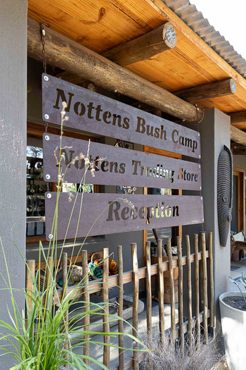 Notten's Bush Camp: Rustikales Empfangsschild aus Holz mit Maske