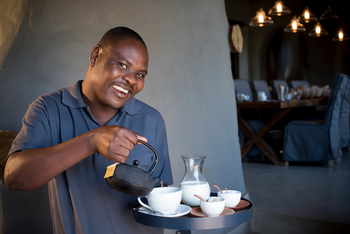 andBeyond Phinda Rock Lodge: Lächelnder Gastgeber beim Tee in Lounge