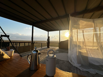 Lion House Sleep-out: Holztisch mit Kessel im goldenen Licht