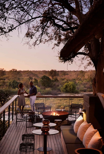 Singita Boulders Lodge: Gäste am Feuer bei Sonnenuntergang