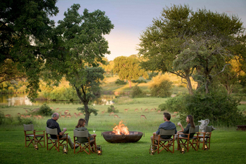 Singita Castleton: Gäste genießen Sundowner am Buschfeuer