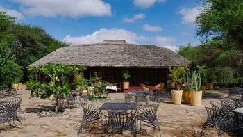KIA Lodge: Rustikale Terrasse mit Metallmöbeln und Pflanzen