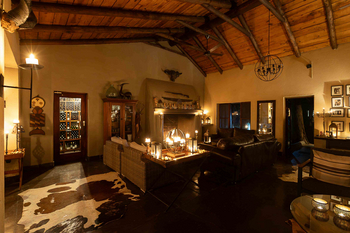 Notten's Bush Camp: Abendliche Lounge mit Rattansofas und Kaminfeuer