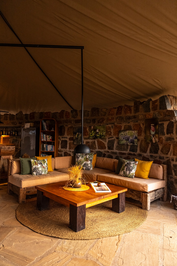 Mkomazi Wilderness Retreat: Lounge mit rustikalem Sofa und Zebradessin-Kissen