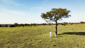 Ikoma Tented Camp: Zwei Gäste beobachten Savannenlandschaft am Morgen