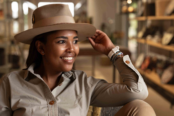 Singita Sweni Lodge: Gast entspannt in Safari-Lounge mit Wandregalen