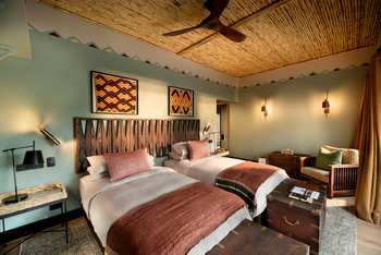 andBeyond Phinda Zuka Lodge: Zweibettzimmer mit Bambusdecke und geschnitztem Kopfteil