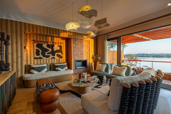 Anantara Tented Camp Kafue River: Lounge mit skulpturalem Couchtisch und Kamin
