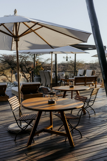 Otjiwa Thornbush Tented Camp: Offenes Buschdeck mit runden Holztischen und Laternen