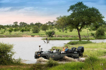 Cheetah Plains: Gäste auf Safarifahrzeug durchqueren seichten Buschfluss