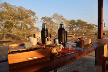 Lion House Sleep-out: Morgenkaffee auf rustikalem Holztisch