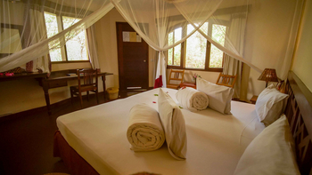 KIA Lodge: Schlafzimmer mit Holzdetails und Moskitonetz
