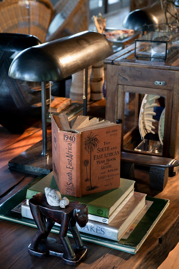 andBeyond Phinda Forest Lodge: Leseecke mit antiker Lampe und Afrikabüchern