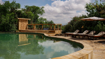 KIA Lodge: Poolterrasse mit vier Liegestühlen und Sonnenschirm