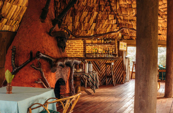 Crater Forest Tented Camp: Rustikale Bar mit Chevron-Holzfront und Flaschenregal