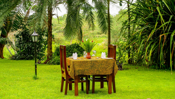 Arusha Safari Lodge: Rustikale Gartentafel mit üppigem Grün