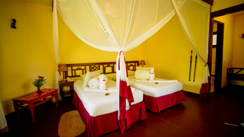KIA Lodge: Schlafzimmer mit Moskitonetz und Blumen