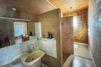 Fort Sesfontein Lodge: Naturverputztes Badezimmer mit Keramikbecken und Wandspiegel