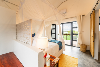 Lenyebi River Lodge: Bett und bodentiefe Fenster