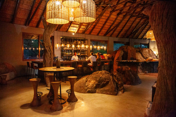 Madikwe Hills Private Game Lodge: Gemütliche Bar mit Natursteinelementen und Holzmöbeln