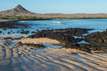 andBeyond Galapagos Explorer: Zerklüftete Vulkanküste mit roten Krabben im Goldlicht