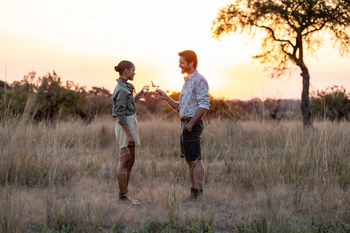 Anantara Tented Camp Kafue River: Zwei Gäste beim Sundowner in der Savanne