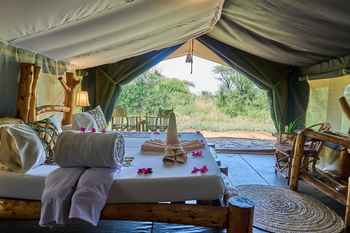 Ikoma Tented Camp: Bett mit Handtüchern und Blütenblättern