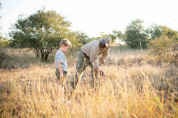 Singita Lebombo Lodge: Guide zeigt Kind Spuren im Busch