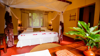 Moivaro Lodge: Bett mit Moskitonetz und Blumen Arrangement
