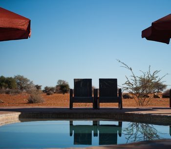 Kalahari Anib Lodge: Pool mit Liegestühlen